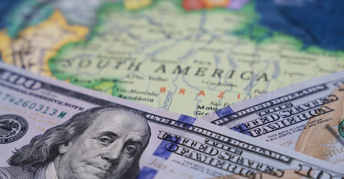 billetes de dolar sobre el mapa de suramérica.