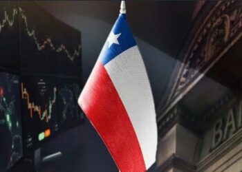 Pantalla con gráficos financieros, fallada de banco y bandera de Chile