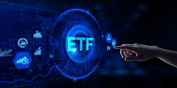 una mano a punto de hacer clic en una pantalla digital donde se lee ETF