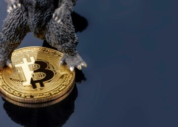 la parte inferior de un mosntruo con rasgos de dinosaurio sobre una moneda de Bitcoin