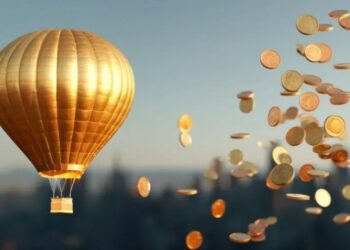 UN globo aeroestático dorado y numerosas monedas doradas cayendo del cielo