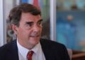 Tim Draper aparece en primer plano sentado ofreciendo una entrevista.