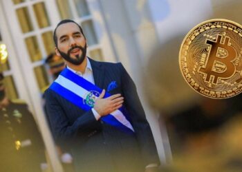 El presidente de El salvador, Nayib Bukele, y un bitcoin a su derecha.