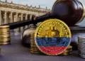Una moneda tricolor de bitcoin se muestra en la plaza Bolívar de Bogotá junto con un mazo regulatorio.