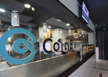 Pizzeria con el nombre de CoinEx escrito en la pared de vidrio del frente.