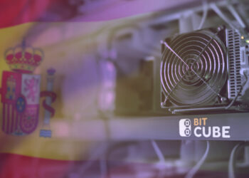 Equipo ASIC de minería de bitcoin con la bandera de España al fondo.