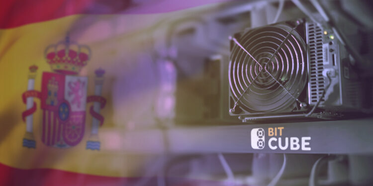 Equipo ASIC de minería de bitcoin con la bandera de España al fondo.