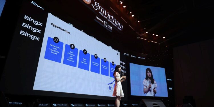 Vivien Lin, del exchange BingX, dando una conferencia en un escenario con dos pantallas
