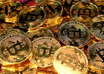 Puñado de monedas doradas de bitcoin.