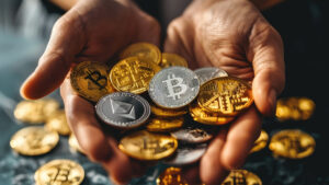 Un puñado de criptomonedas de bitcoin y Ethereum en las palmas de unas manos masculinas.