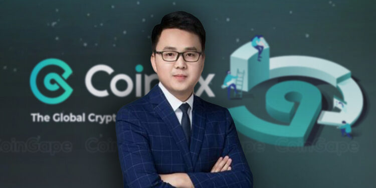 Haipo Yang, CEO de CoinEx, de traje y corbata azul frente al logo de CoinEx.