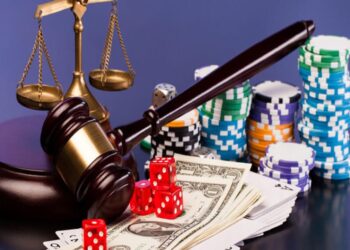 Fichas y dados de casino junto a un mazo de juez y la balanza de la justicia.