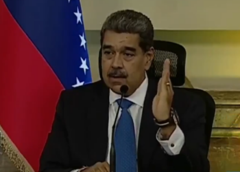Nicolas Maduro con bandera de Venezuela a su derecha.