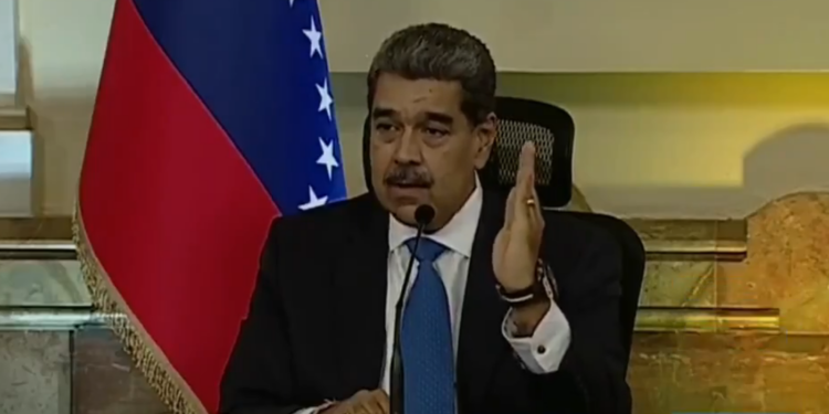 Nicolas Maduro con bandera de Venezuela a su derecha.