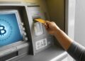 Una persona retirando dinero en efectivo de un cajero habilitado para bitcoin.
