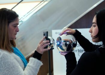 Una mujer escaneándose en un Orb de Worldcoin.