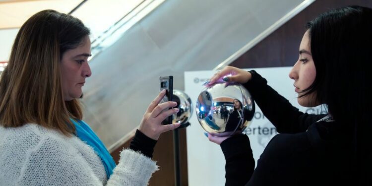 Una mujer escaneándose en un Orb de Worldcoin.
