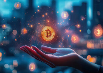 Una mano de mujer sobre la cual flota una moneda dorada de bitcoin.