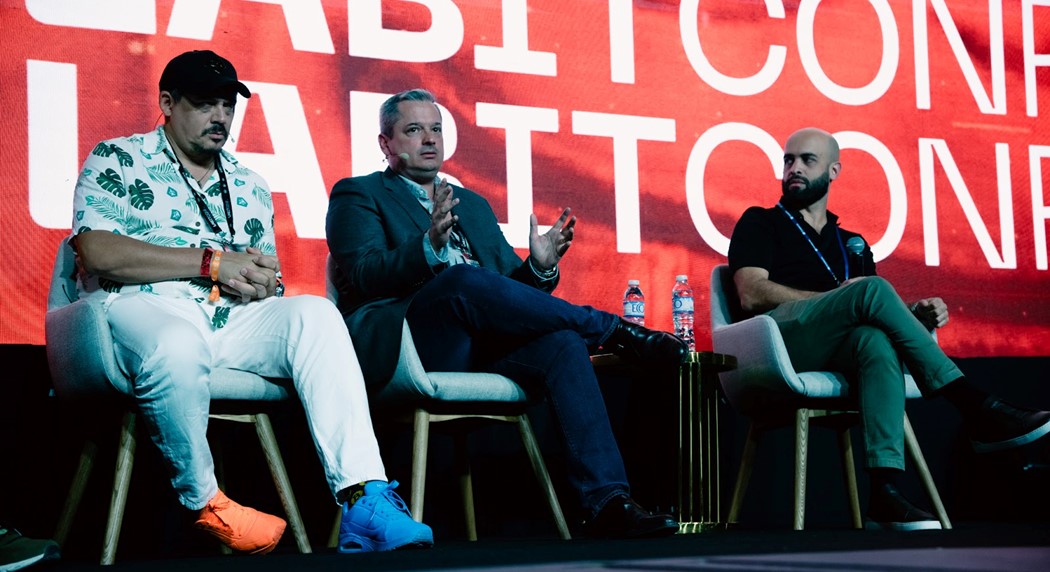 Tres hombres sentados en el stage de la conferencia LaBitConf.