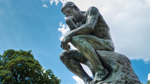 Una estatua de un hombre sentado pensando.