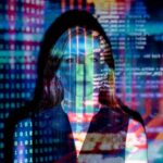 Mujer de pelo rubio reflejando las imágenes de una pantalla de computadora.