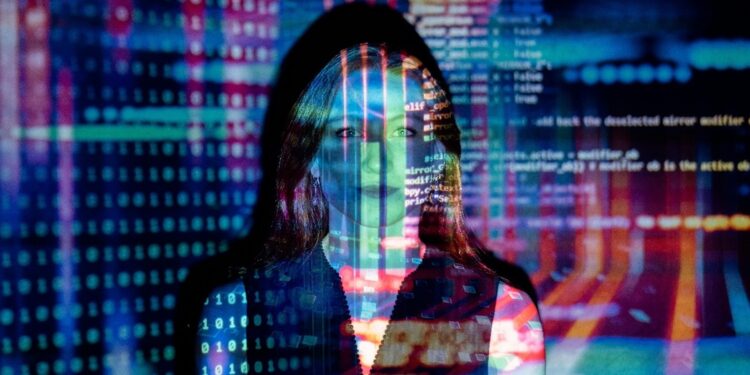 Mujer de pelo rubio reflejando las imágenes de una pantalla de computadora.
