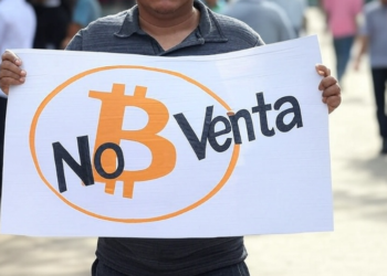 Una persona sostiene un cartel en el que se lee que Bitcoin no está en venta.