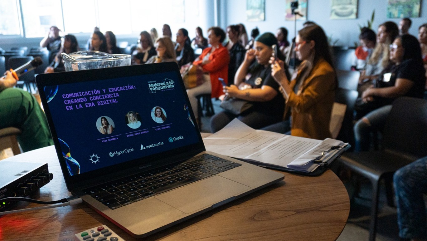 Varias mujeres sentadas reunidas en un salón.