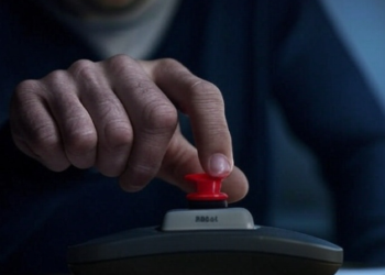 Una mano pulsando un botón rojo de reinicio.