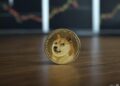 Una moneda con el logo de dogecoin sobre una mesa.