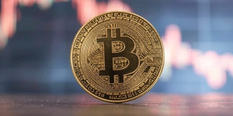 moneda de bitcoin sobre una mesa con un gráfico de precios en el fondo.