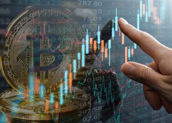 Imagen de moneda de bitcoin con gráfico de precios alcista y la mano de un analista señalando.