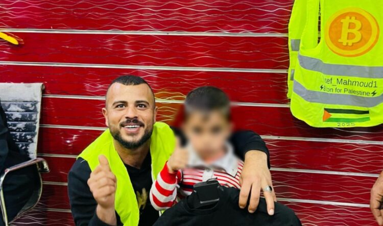 Fotografía de un niño recibiendo una donación de la organización Bitcoin For Palestine.