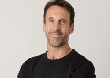 Una persona de brazos cruzados con una remera negra.