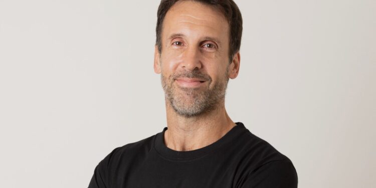Una persona de brazos cruzados con una remera negra.