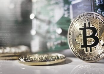 Varias monedas de bitcoin sobre una mesa.