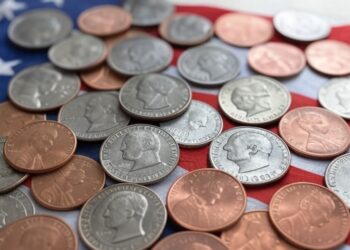 Imagen generada por la IA Grok de monedas sobre una bandera de EE. UU.