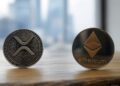 Dos monedas sobre una mesa, una con el logo de XRP y otra con el de Ethereum.