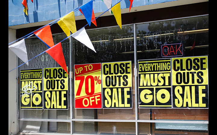 Tienda de muebles con anuncios de rebajas y ventas totales.