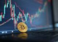 moneda de bitcoin con un gráfico de fondo.