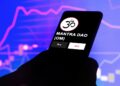 Un celular que se ve el logo del token mantra (OM).