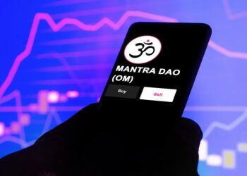 Un celular que se ve el logo del token mantra (OM).