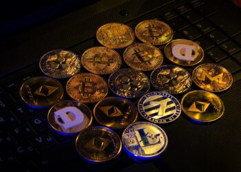 Muchas criptomonedas doradas sobre un fondo negro.