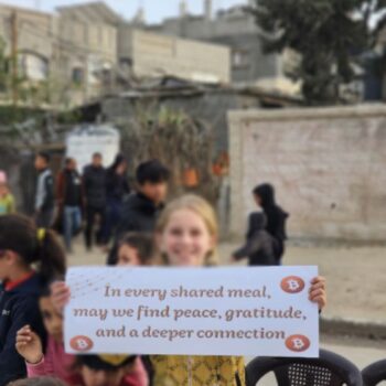 Niña palestina sosteniendo un cartel con un mensaje en Gaza.