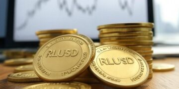 Monedas con el logo de Ripple USD (RLUSD) sobre una mesa.