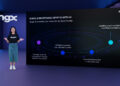 Una persona está de pie frente a una pantalla grande con el logotipo de BingX. La pantalla dice: "BingX está redefiniendo el cripto con IA. BingX AI Evolution.