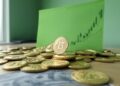 Monedas de bitcoin con gráfico verde en el fondo.
