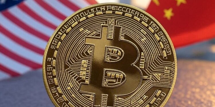 Una moneda dorada con el logo de bitcoin, delante de las banderas de Estados Unidos y China.