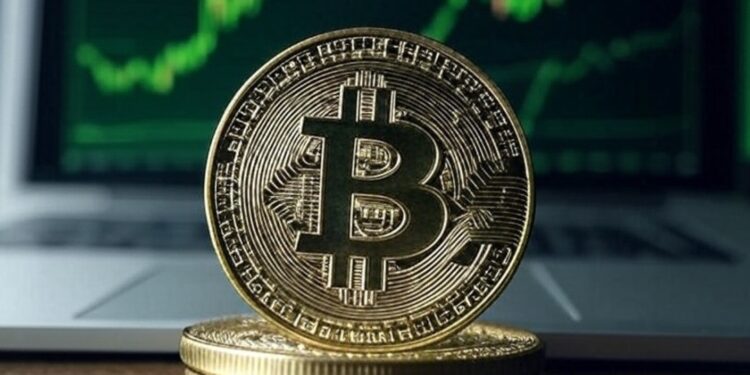 Imagen de bitcoin sobre un escritorio con gráficas verdes en el fondo.