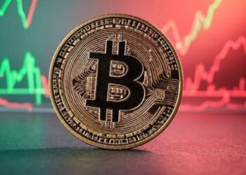 Una moneda de Bitcoin con un fondo de gráficas verdes y rojas.